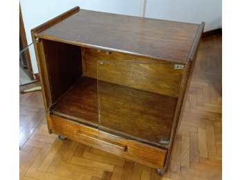 Pequeña vitrina con un cajon y rueditas